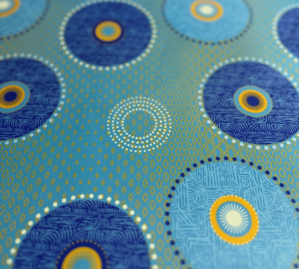 Patterned fabric with blue and yellow circles on a teal background