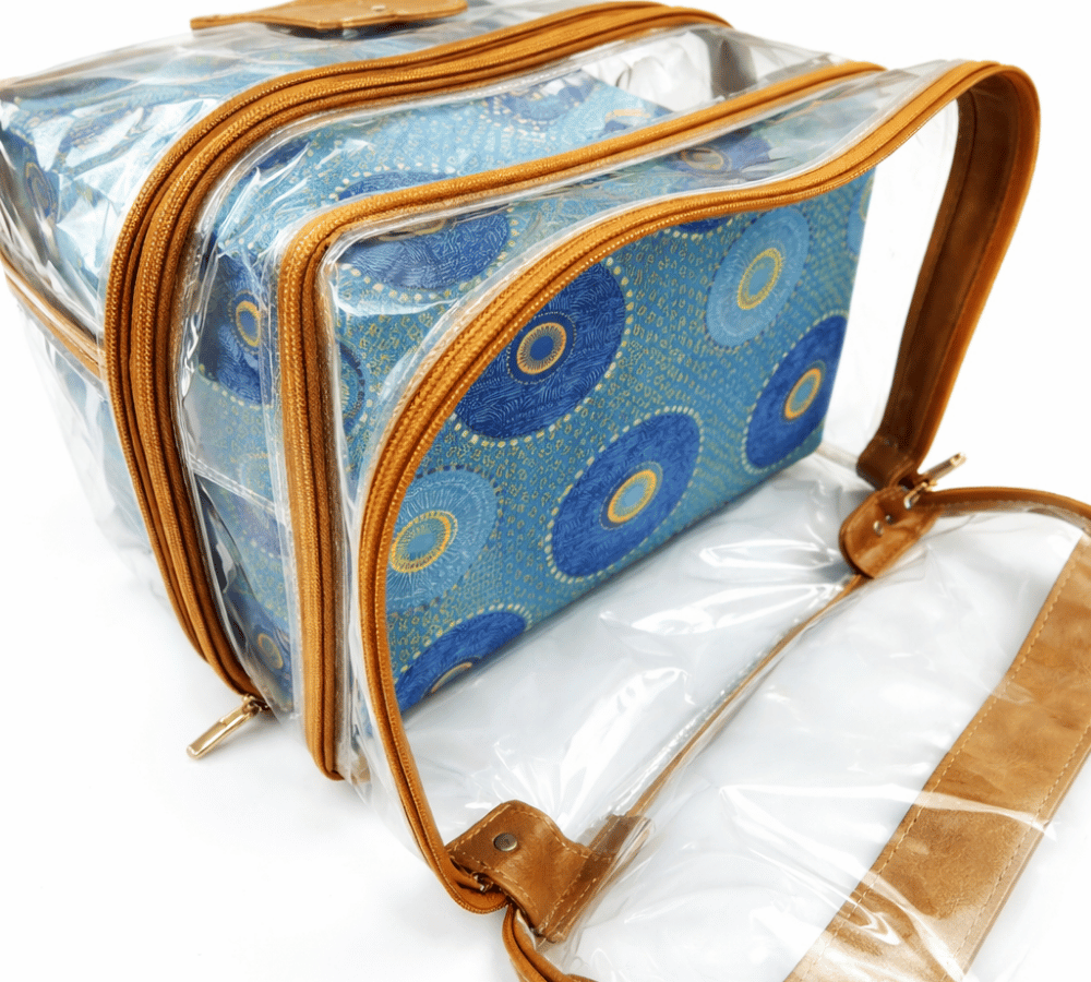 Humba Hides Multipurpose bag with duel waterproof clear compartments, brown leather trim with zips and Blue 
Shweshwe patterned interior on a white background