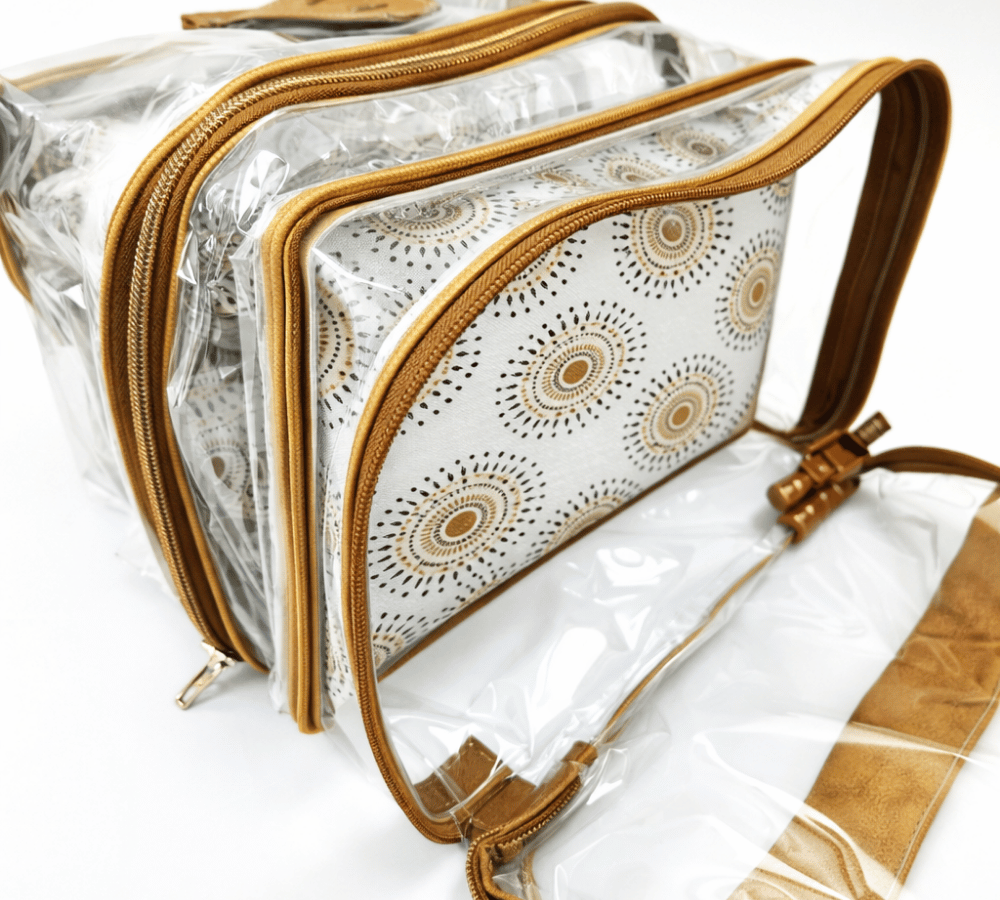Humba Hides Multipurpose bag with duel waterproof clear compartments, brown leather trim with zips and Neutral Shweshwe patterned interior on a white background