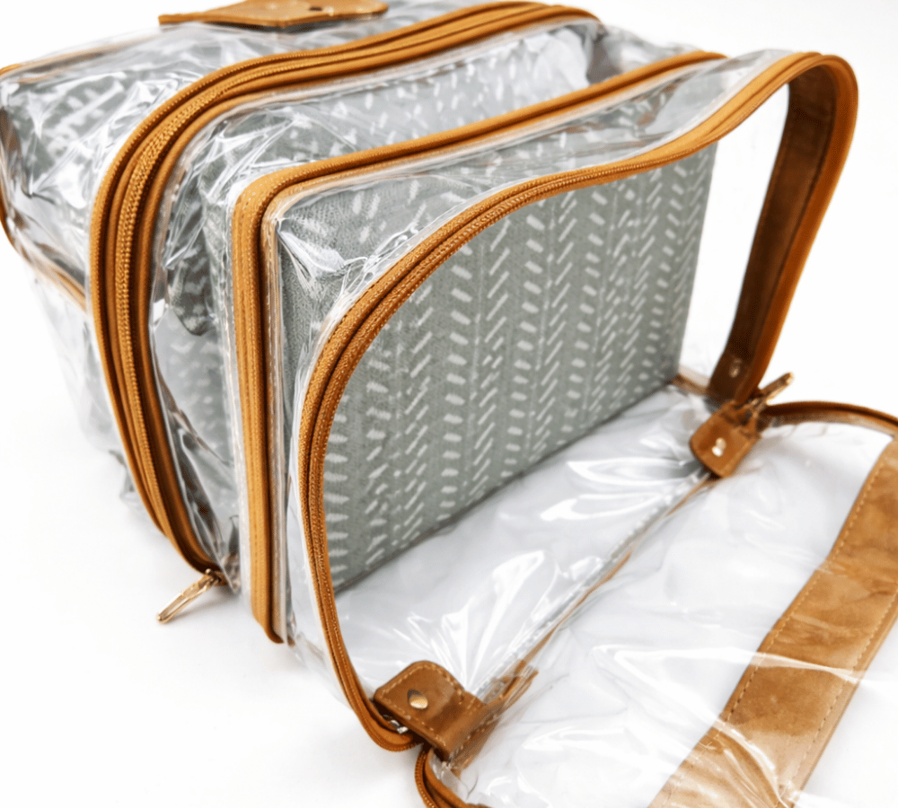 Humba Hides Multipurpose bag with duel  waterproof clear compartments, brown leather trim with zips and Sage Affair patterned interior on a white background