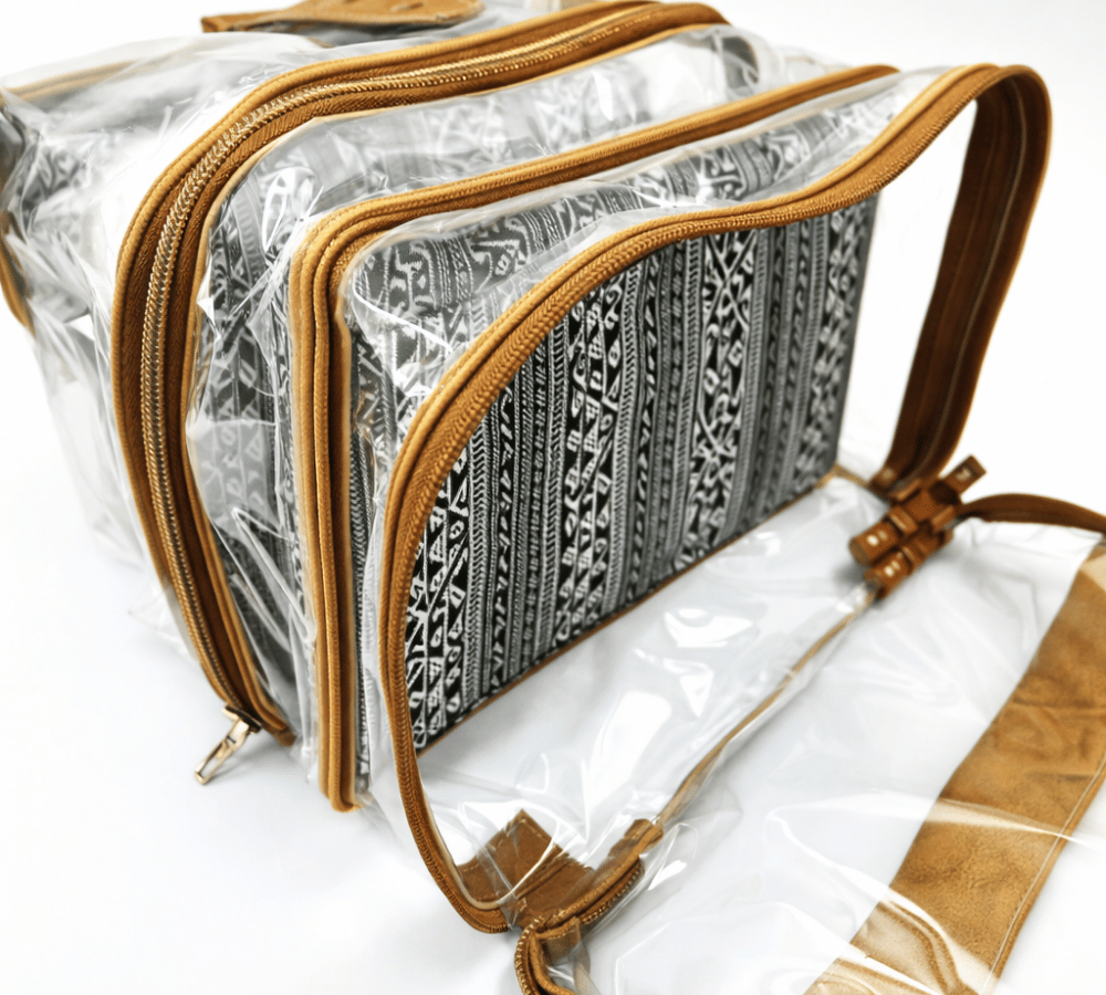 Humba Hides Multipurpose bag with duel waterproof clear compartments, brown leather trim with zips and African Stripe patterned interior on a white background