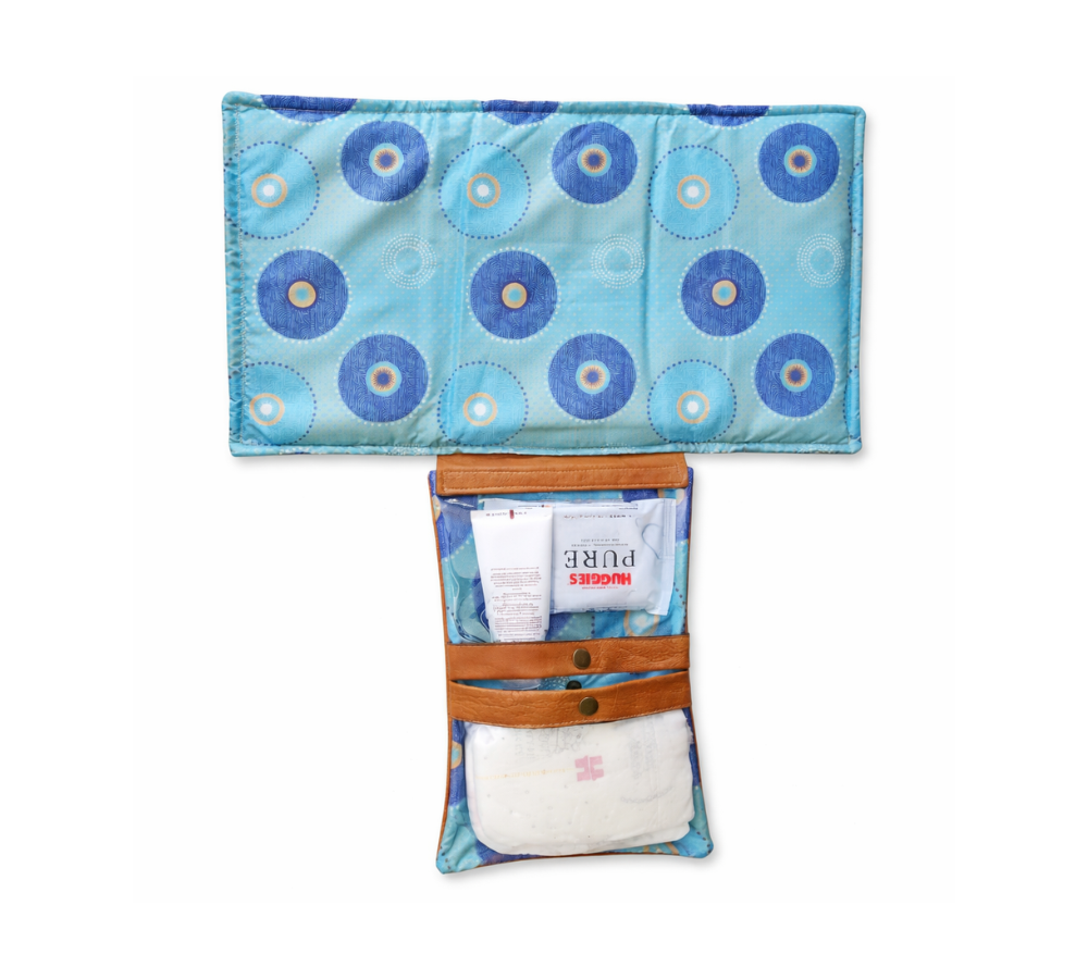 Humba Hides Travel Clutch – An open Portable Nappy Changing Station showing Blue Shweshwe pattern in waterproof material and genuine leather backing on a white background